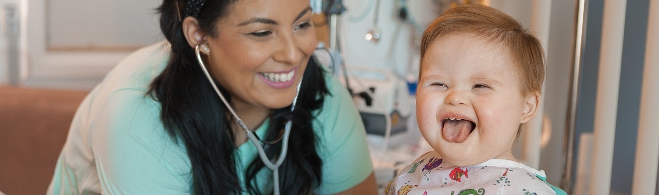 nursing holding stethoscope to young child